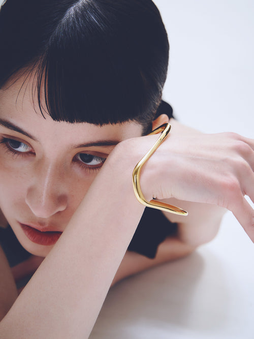 Wave Bracelet in Gold worn on wrist, close-up view |Color:Gold